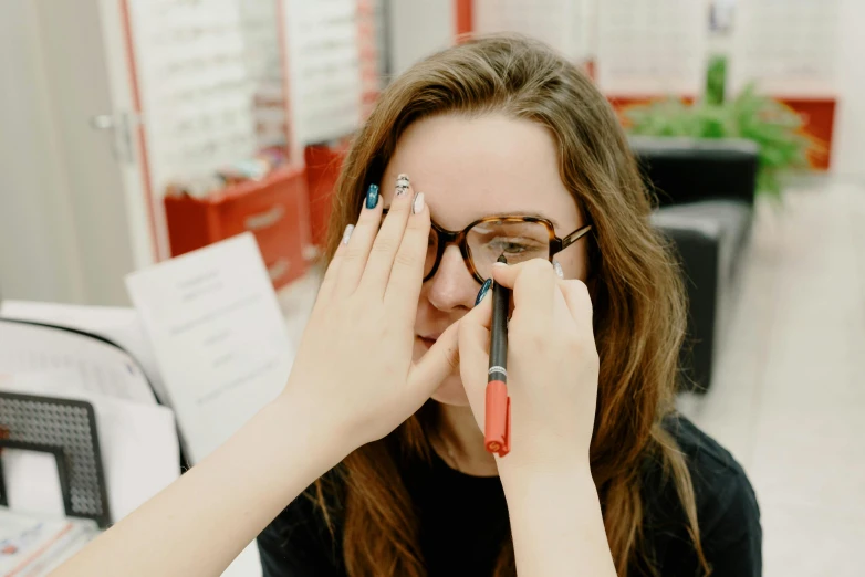 the young woman is putting her eye glasses on