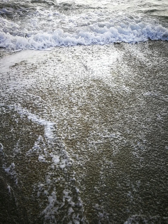 a wave coming in onto a shore line at the ocean