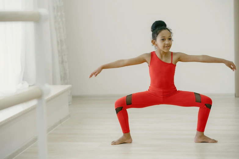 the girl is doing a yoga pose in red