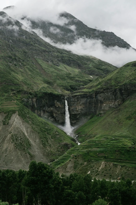 some very tall mountains near a big waterfall