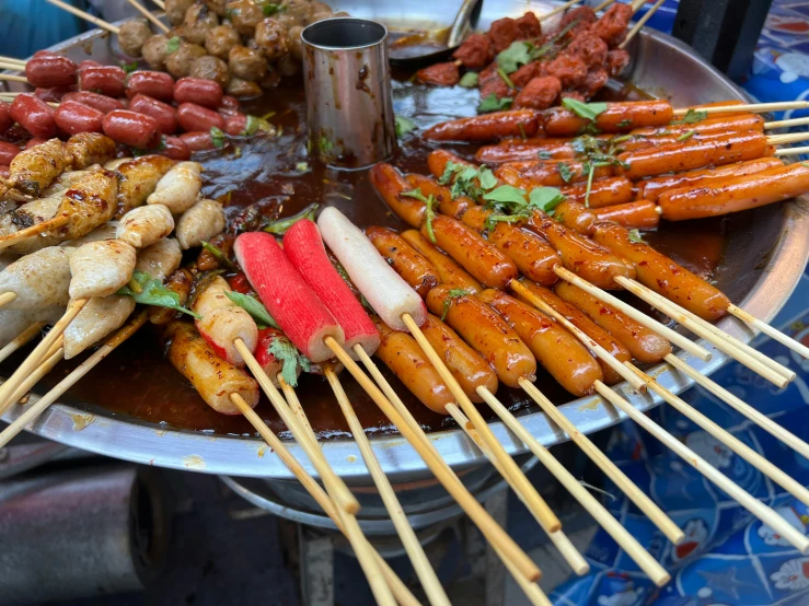 large metal pan with multiple skewers of different kinds of food