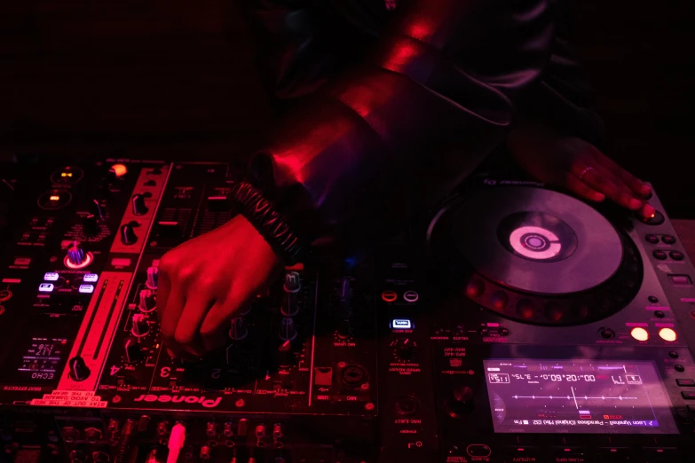 dj mixing at a set with music equipment in foreground