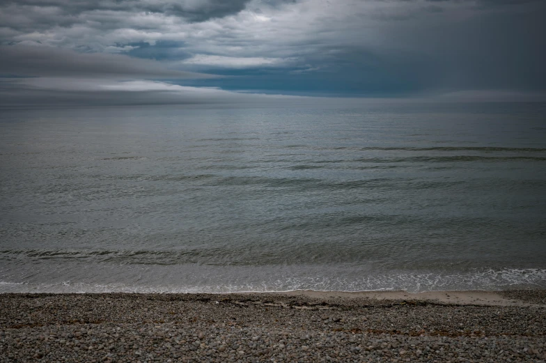 a beach with a dark sky and some water