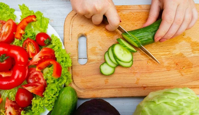 there is a  board with sliced vegetables