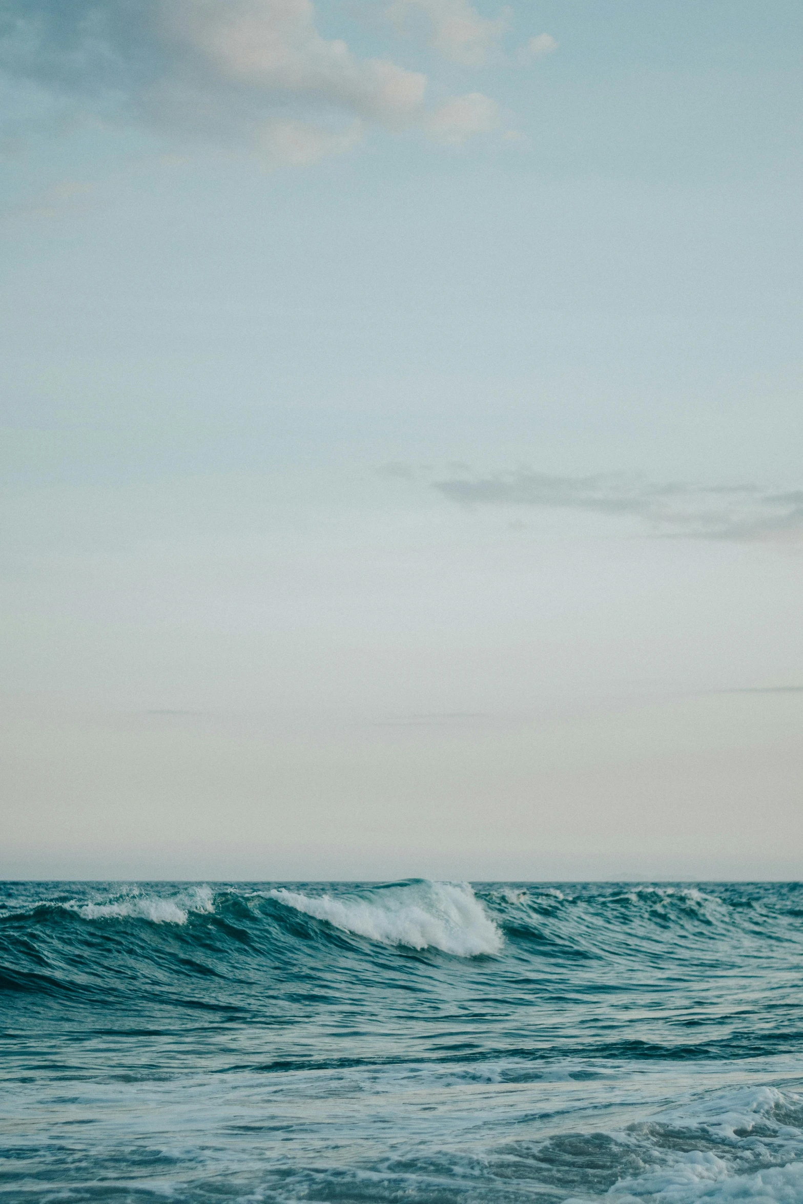 a lone surfer surfs in the ocean during the day