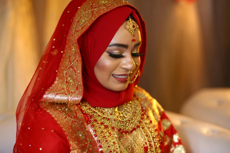 a beautiful young lady in a veil and gold jewelry