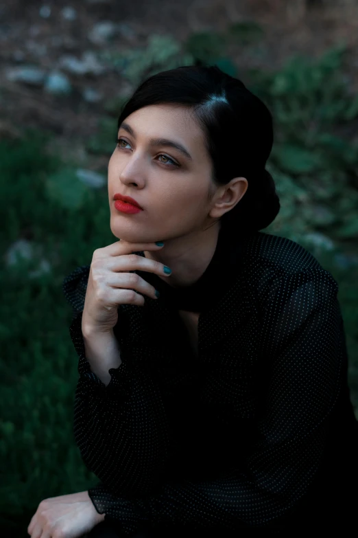 woman with dark hair posing for po in grassy area