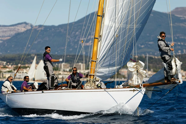 the men are riding on the sailboat in the water