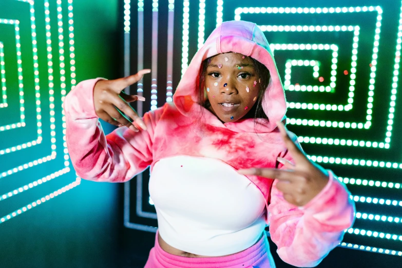 a woman is posing in front of a neon background