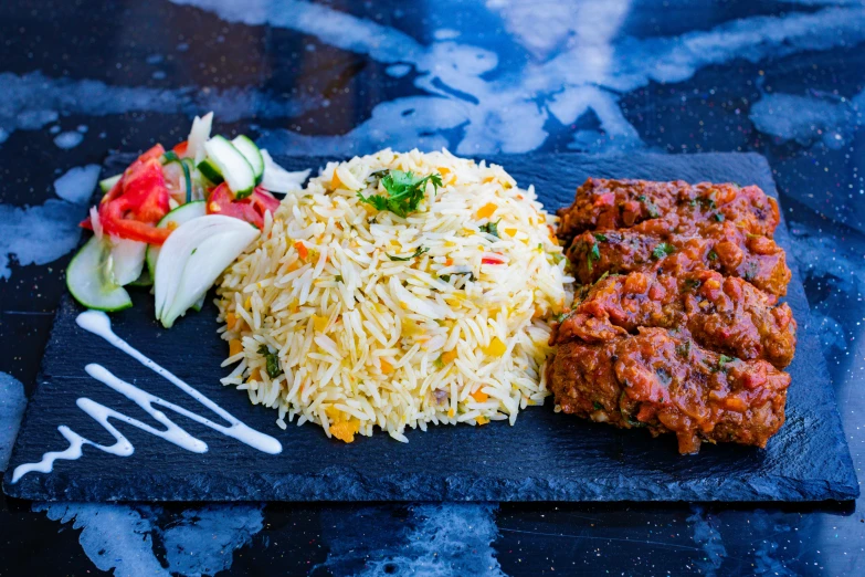 a plate topped with rice, meat and vegetables