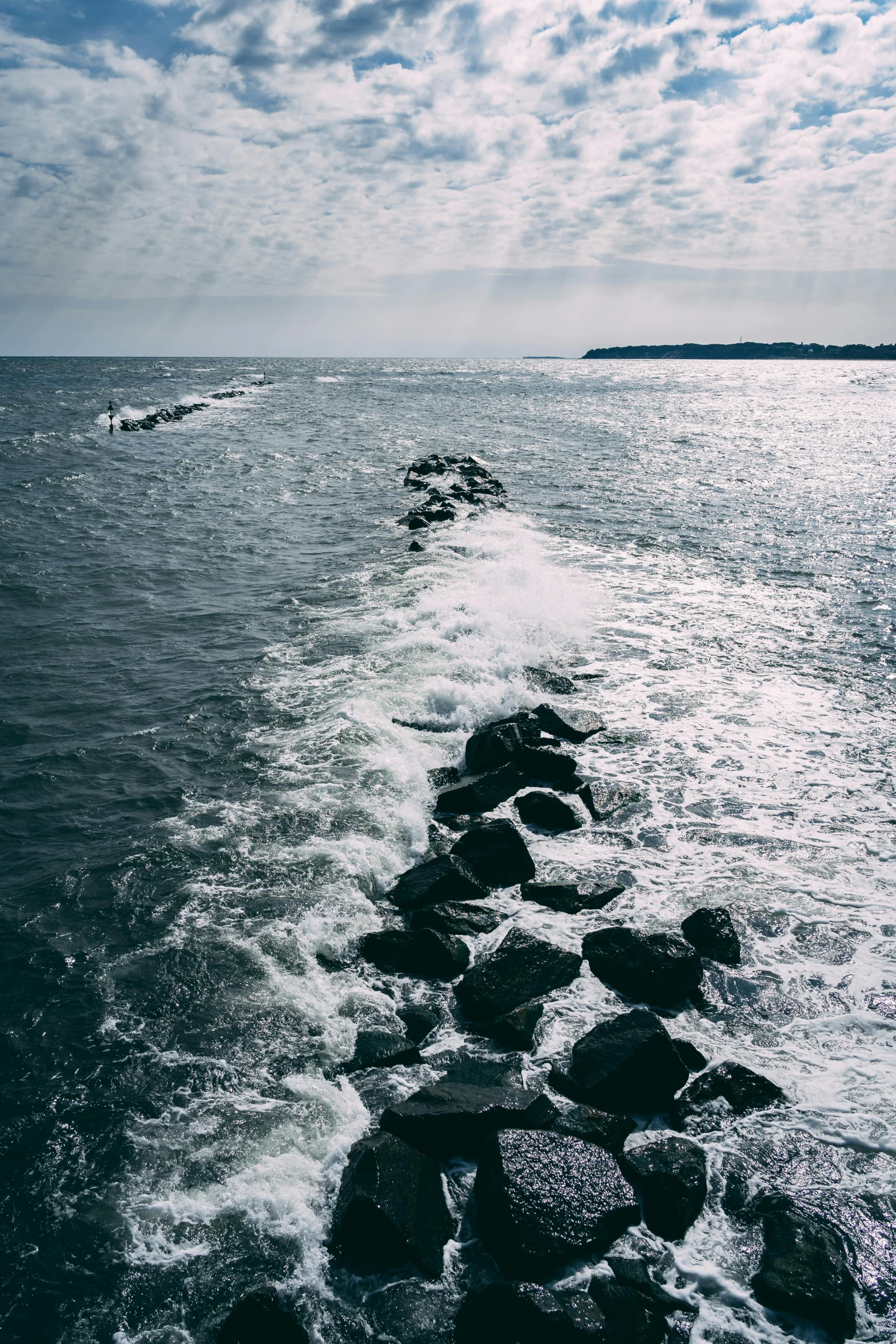 waves roll on rocks along the shore, leaving their wake