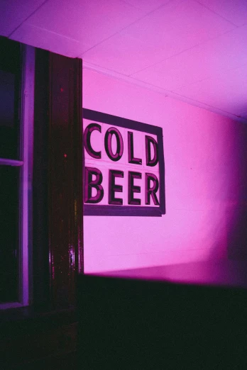 a dark purple background shows the silhouette of a window and sign that reads cold beer