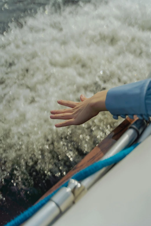 a person's hands and boat handle as the boat rides the water