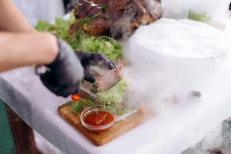 a person putting sauce on a piece of food