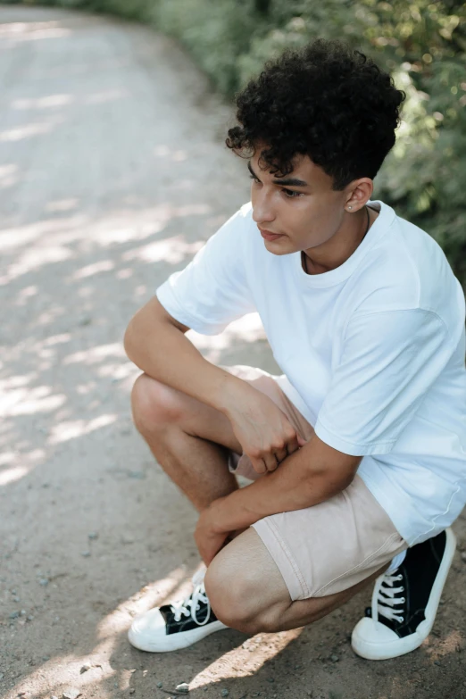 a man sitting on the ground near a park