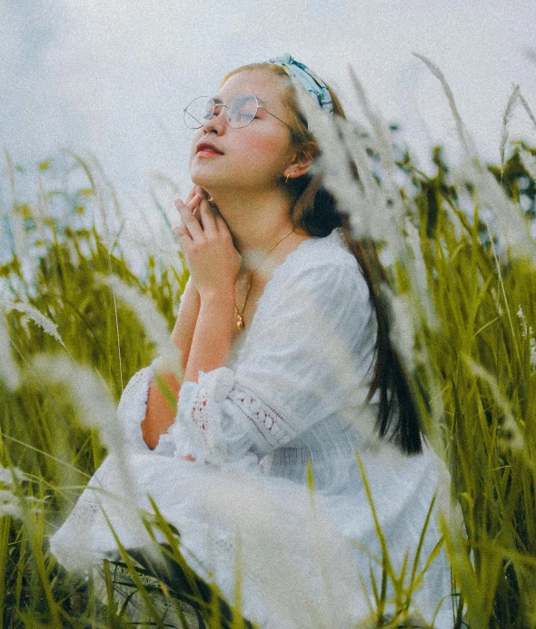 a woman sits in the grass with a face painted on