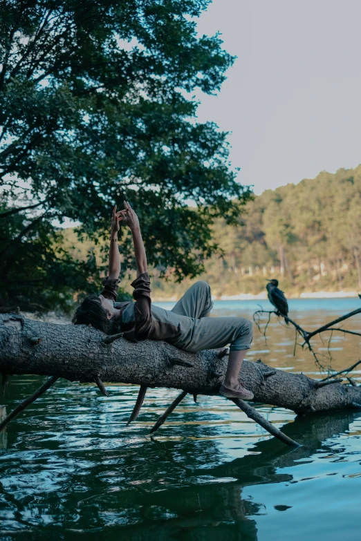 a man is laying on top of a tree nch