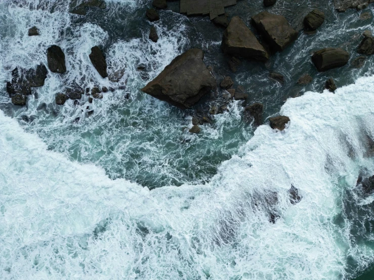 the water is white and blue with rocks