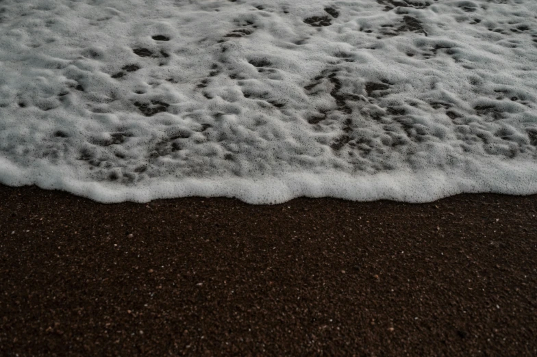 a wet and white beach on the sand