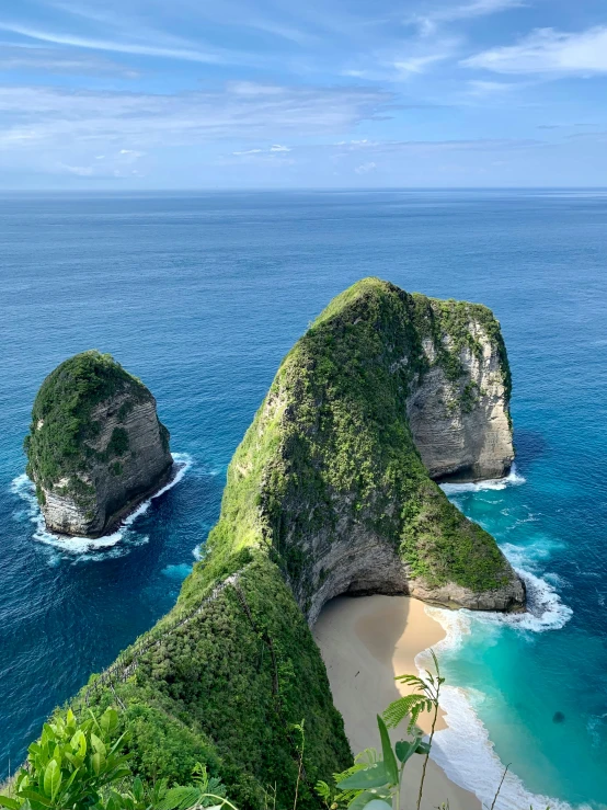 two large hills next to the ocean covered in green vegetation