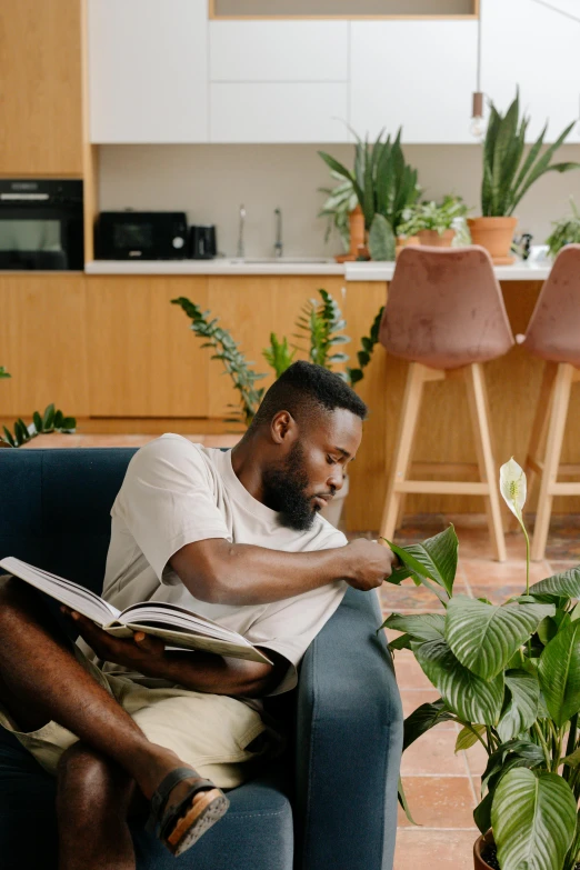 a man sitting on a couch reading a book