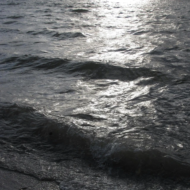 the man is sitting in the ocean and surfing