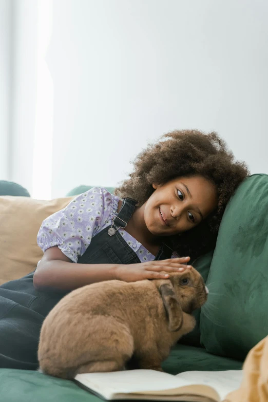 a girl laying on a couch with her dog