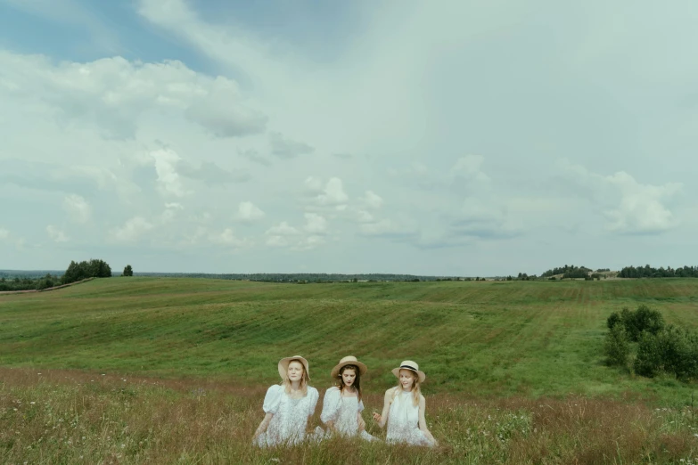 three women in long dresses are standing near each other