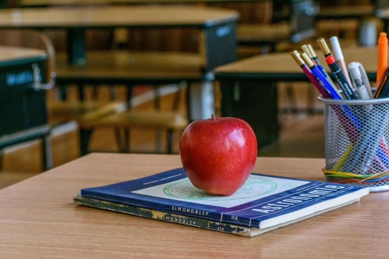 a book and an apple on a desk