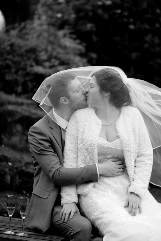 a bride and groom posing for pictures under an umbrella