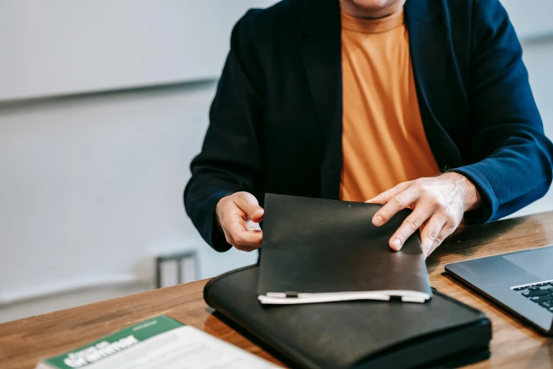 a person sits with a laptop on a table