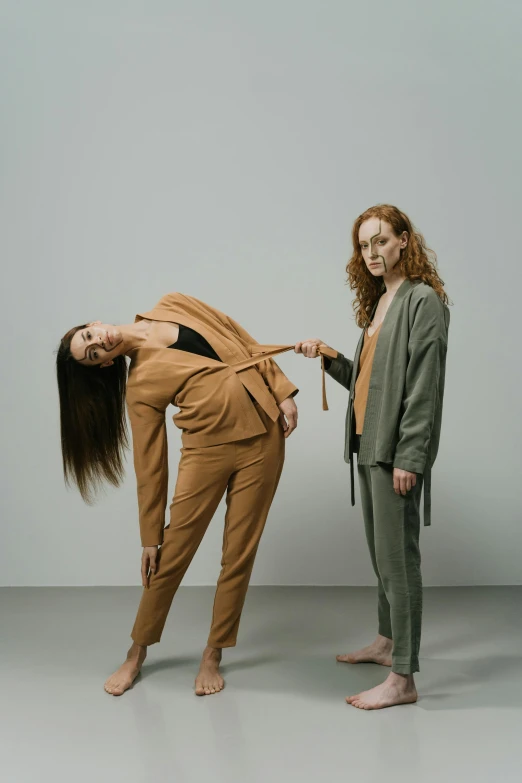 a woman holding onto another woman's tie