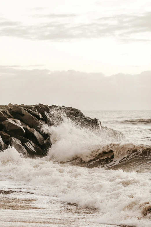 a couple of rocks sit on the side of the ocean