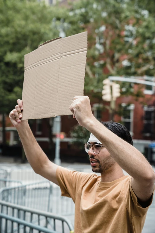 a man is holding up a sign at a street corner