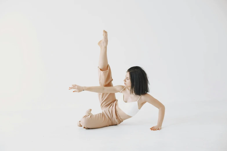 woman doing split ballet exercises on white background