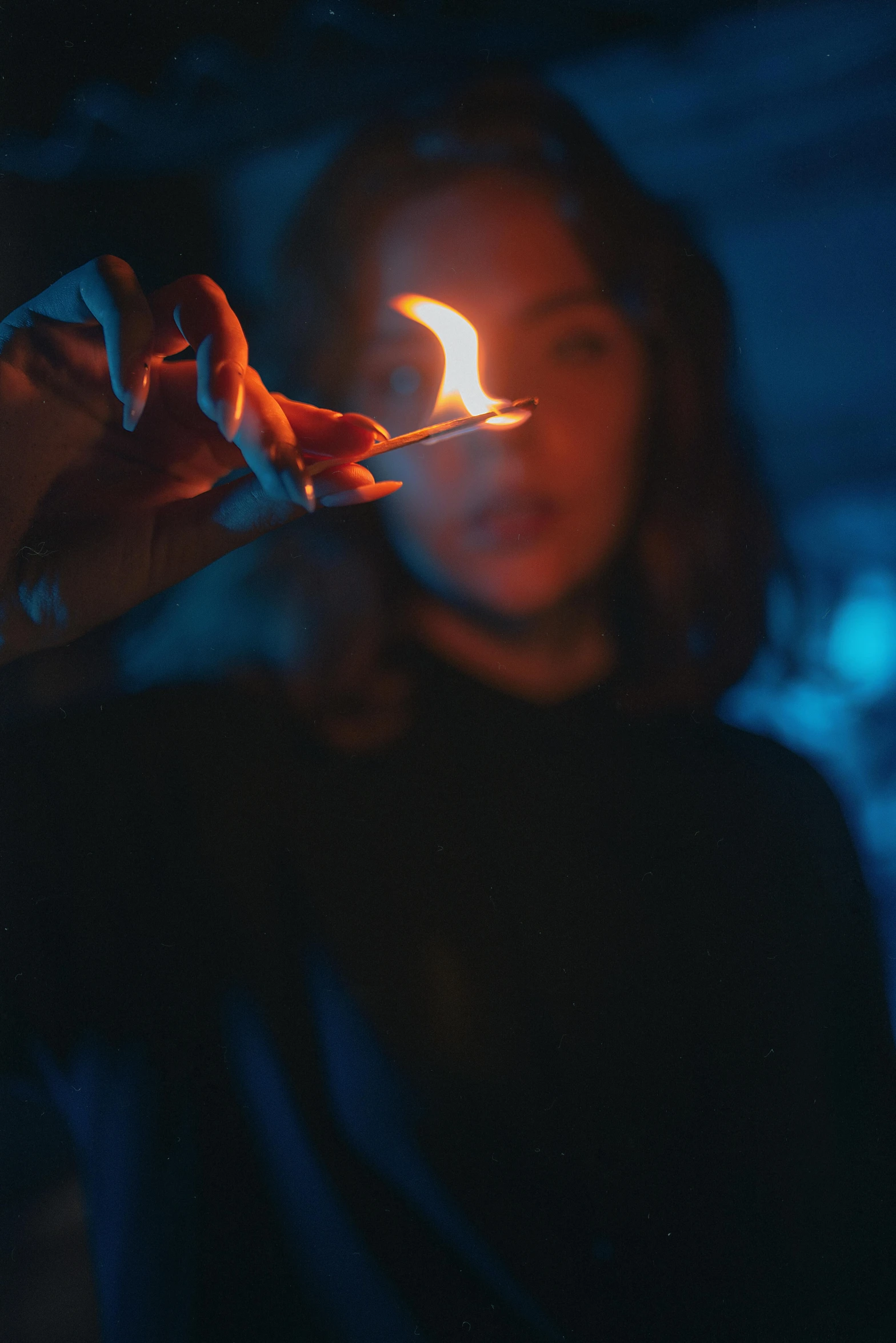 a girl holding up a lit matchstick in her hand