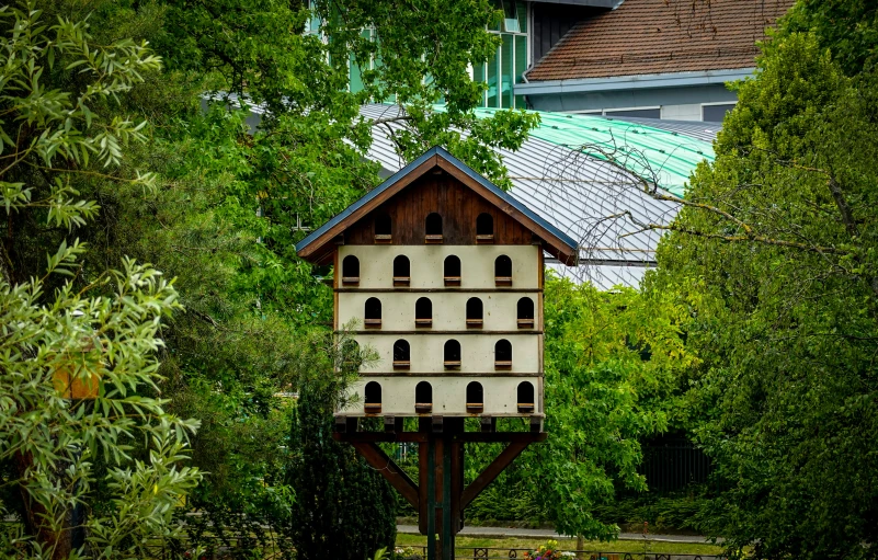 a bird house sitting in the middle of some green trees