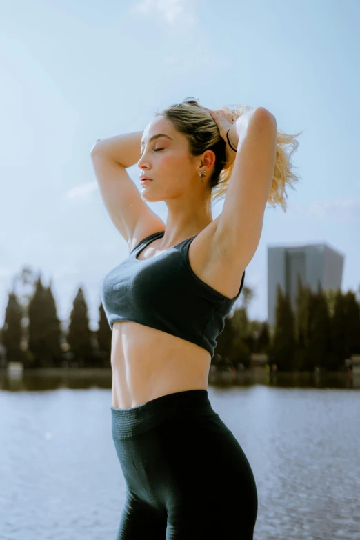 a female in a black top is standing near the water