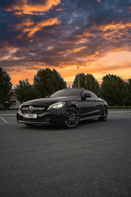 a car sitting in the middle of a parking lot at sunset