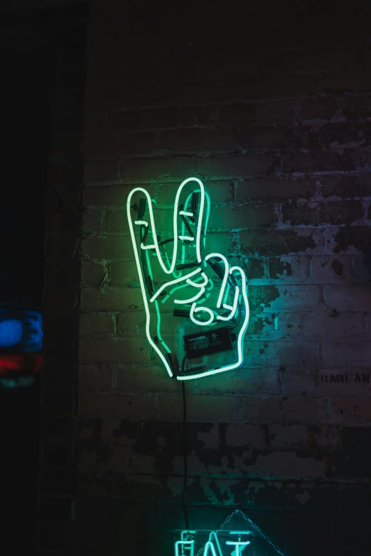 a neon sign with a hand making the v letter