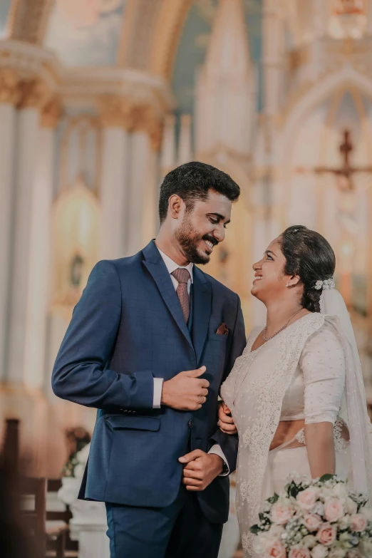 a bride and groom standing together in front of a church