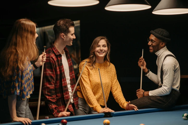 a group of people play a game of pool