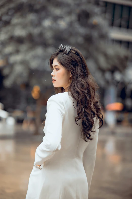 woman in white dress with trees and building