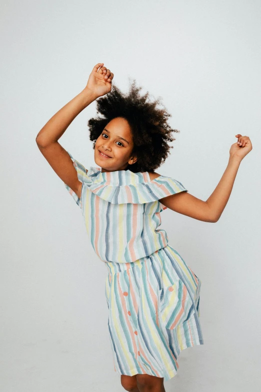 a little girl posing with her arms up