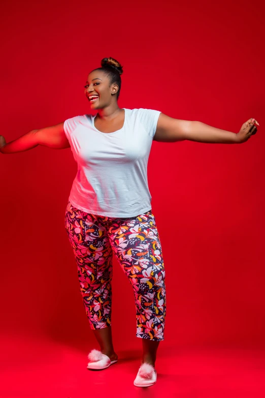 a woman in patterned pants stands and poses