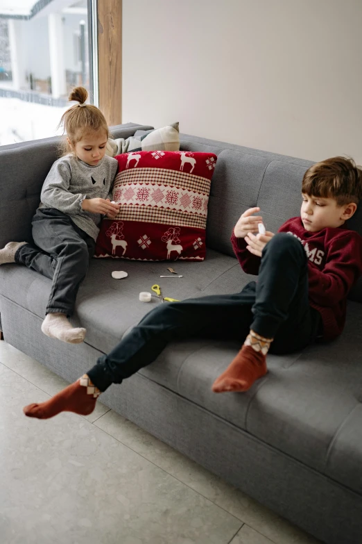 a boy and a girl play on the couch