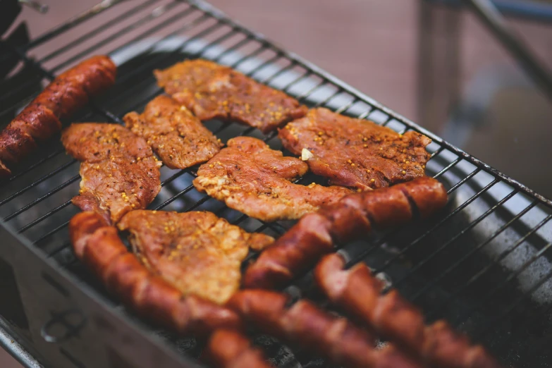  dogs and sausages are cooking on a grill