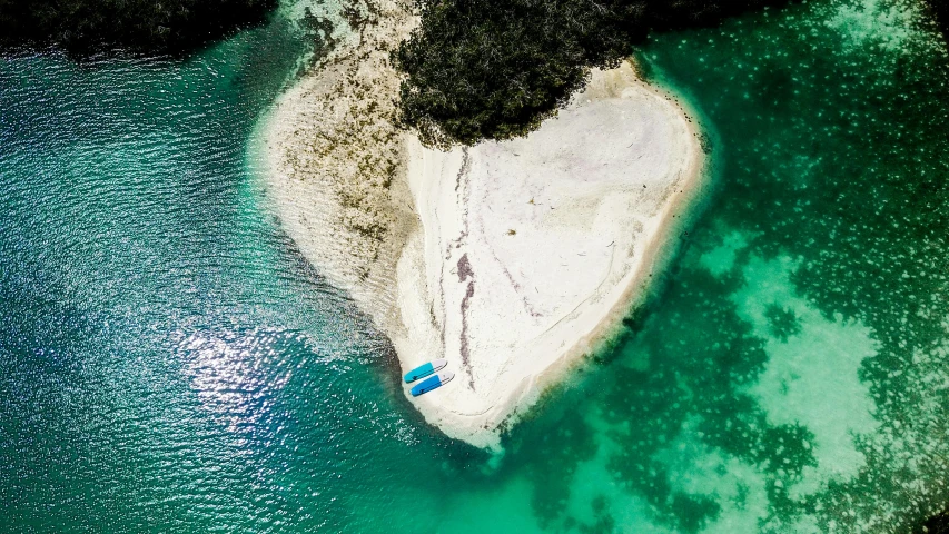 an aerial view of a small island with a boat floating on it