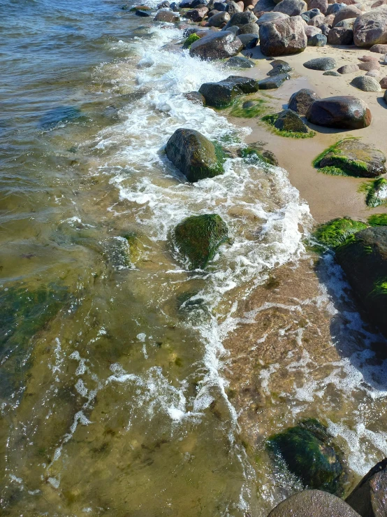 water near rocky shore with stones in background