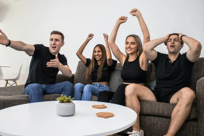 people on a couch celeting with a drink